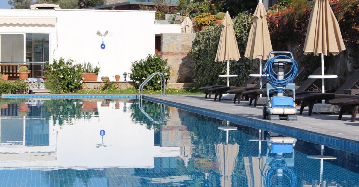 Relax by the serene poolside with lounge chairs and umbrellas at a modern resort.