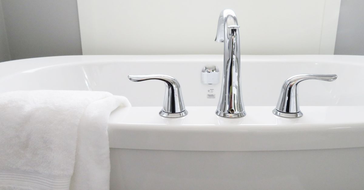 Clean and modern white bathtub with chrome fixtures, perfect for sleek interior design.