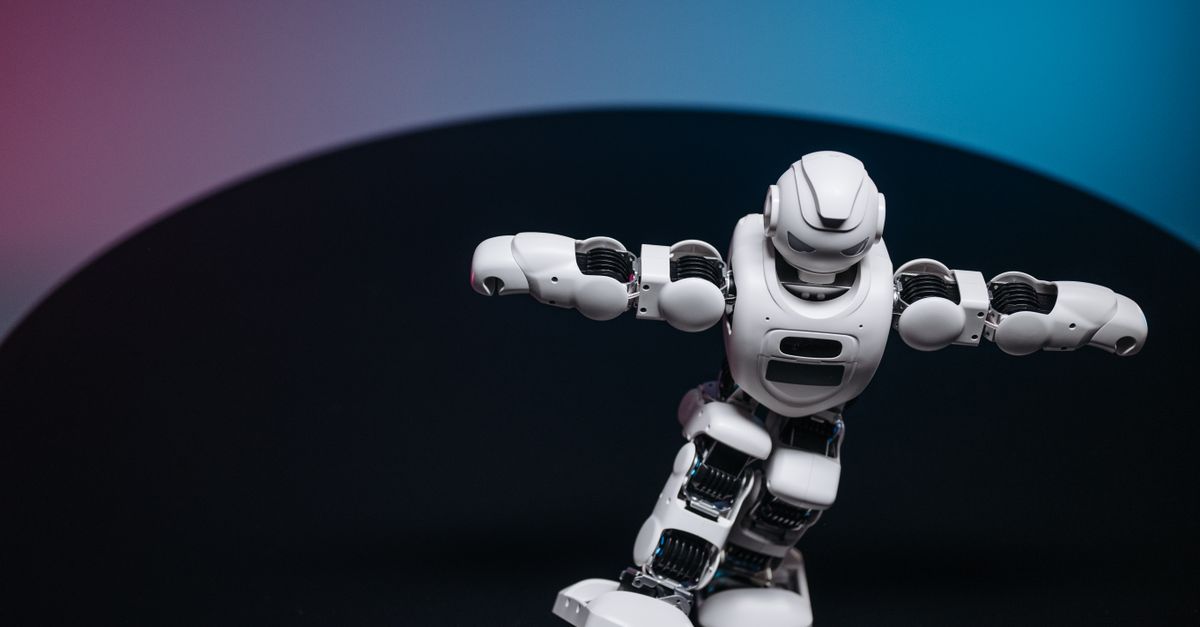 A futuristic white robot toy performing on a sleek dark surface.