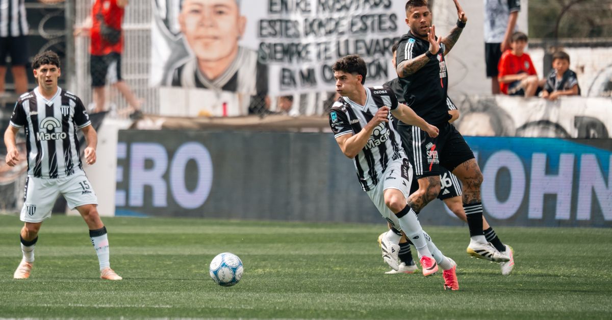 Players in action during a competitive soccer match in a stadium.