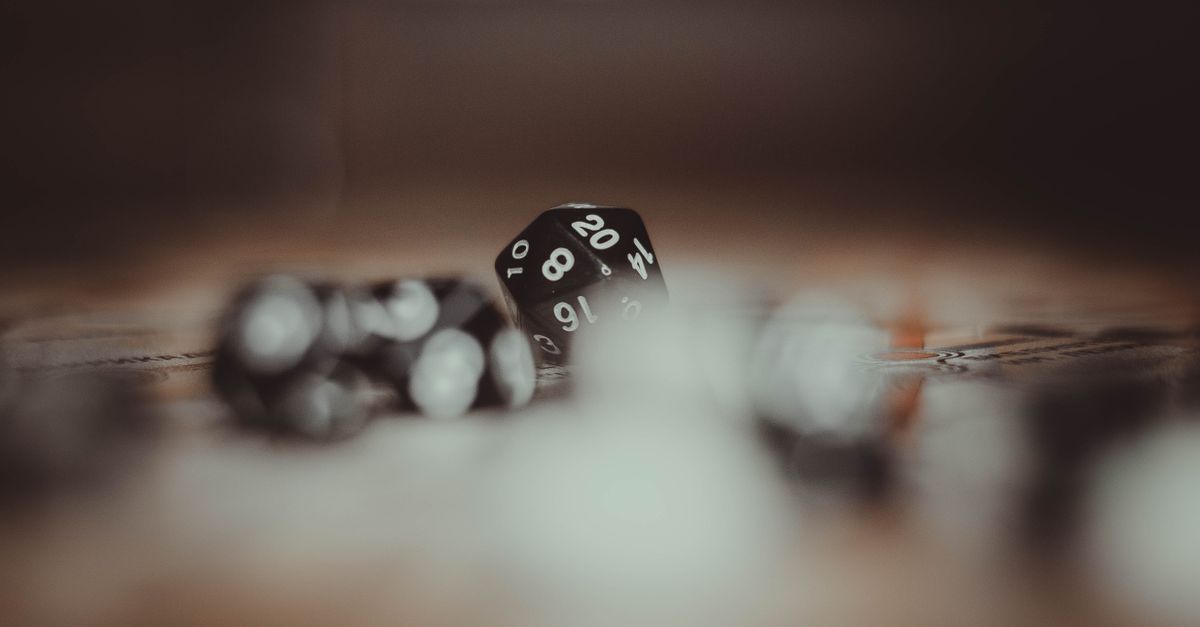 Artistic photo of multi-sided gaming dice in a blurred setting, highlighting the number 20.