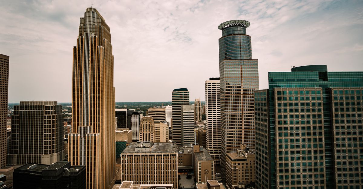Aerial view of the Minneapolis skyline highlighting its diverse architecture under a cloudy sky.