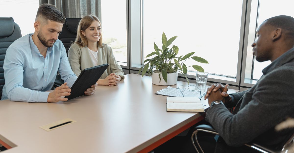 A business interview with three people in a modern office room, highlighting collaboration.