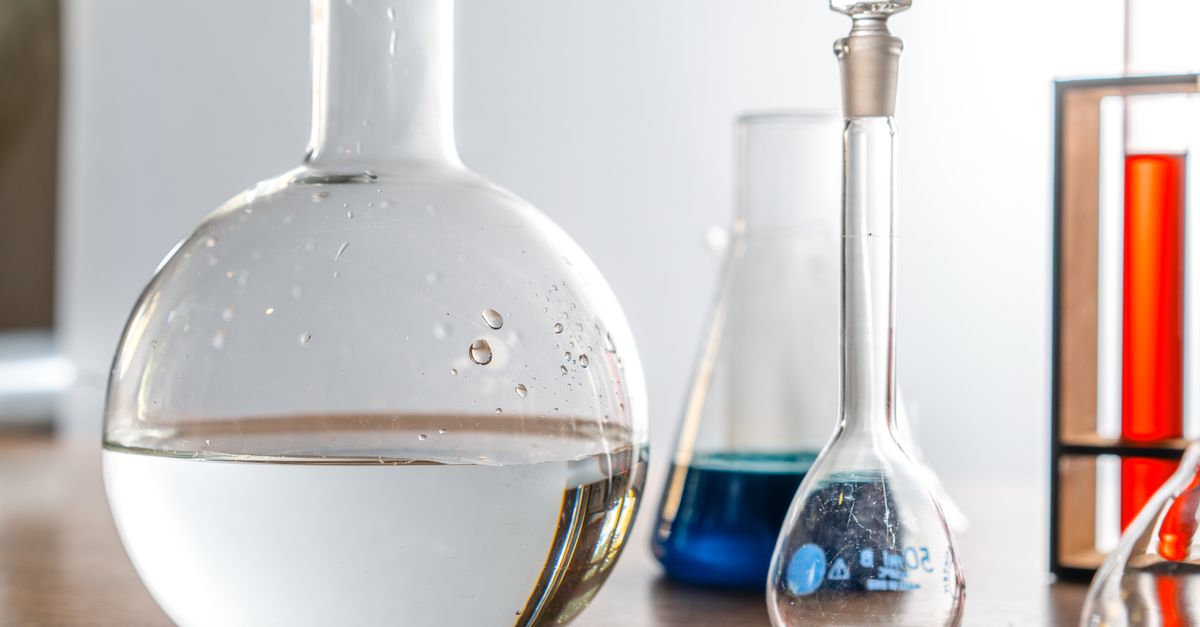 Close-up of laboratory glassware with various chemical solutions in a lab setting.