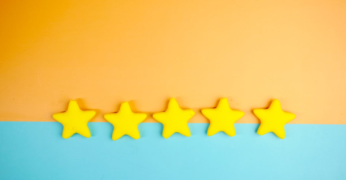 Bright yellow stars arranged on a vivid orange and blue background with copy space.