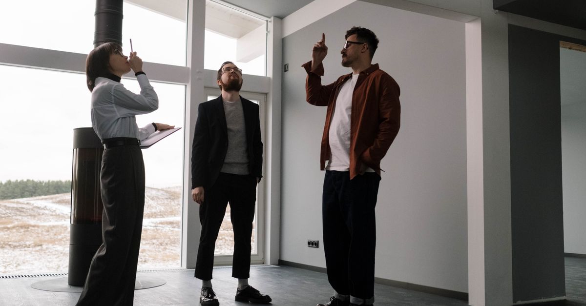 Three real estate agents discussing design in a modern apartment space.
