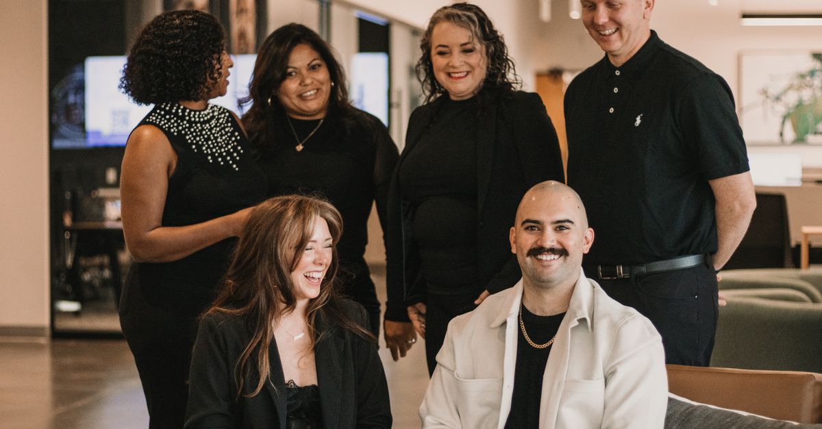 Diverse real estate team engaged in conversation in a modern office setting.