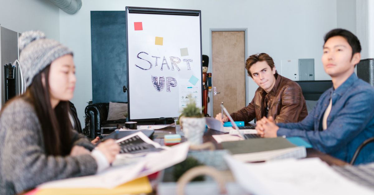 A group of young professionals brainstorming ideas in a startup office setting.