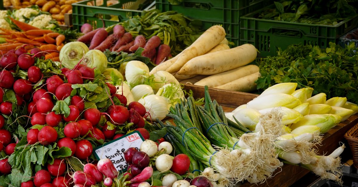 A colorful array of fresh vegetables at a farmer's market stall, showcasing farm-to-table produce.