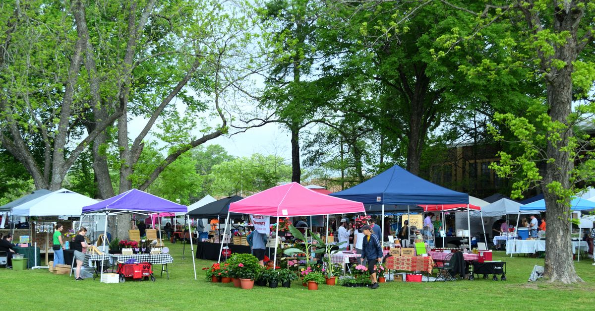 A bustling outdoor market with colorful tents and visitors in Whitehouse, Texas.