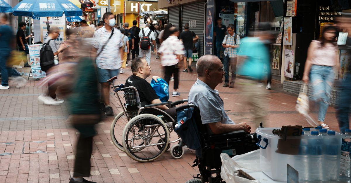 Vibrant city street with wheelchair users and fast-moving shoppers, capturing urban life.