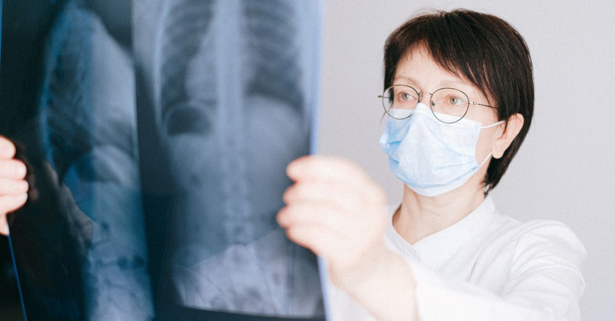 A doctor examines a chest X-ray in a clinical setting, highlighting medical diagnostics.