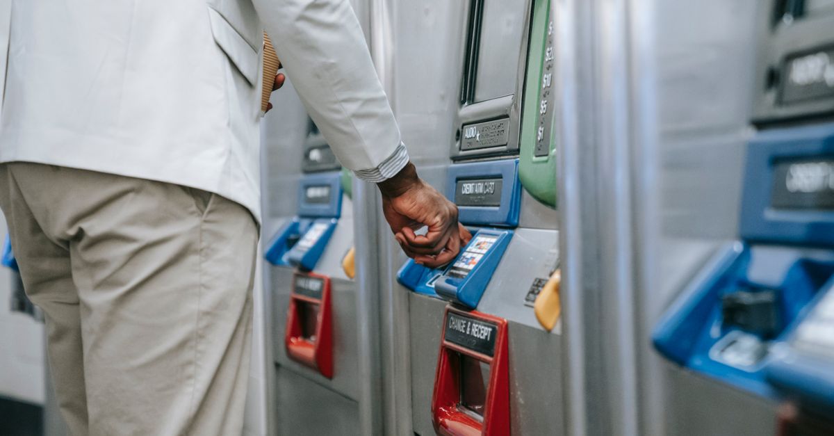 Close-up of a man purchasing a ticket using a modern subway machine.