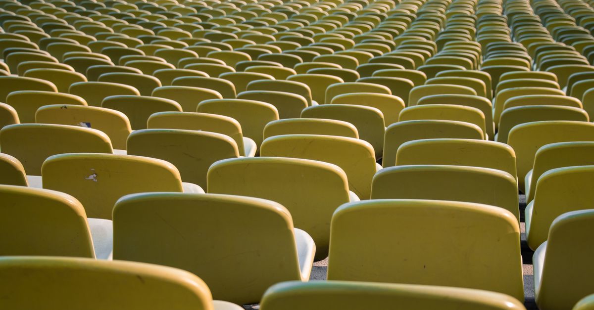 Rows of empty yellow seats in a stadium in Munich, Germany, emphasizing repetition and symmetry.