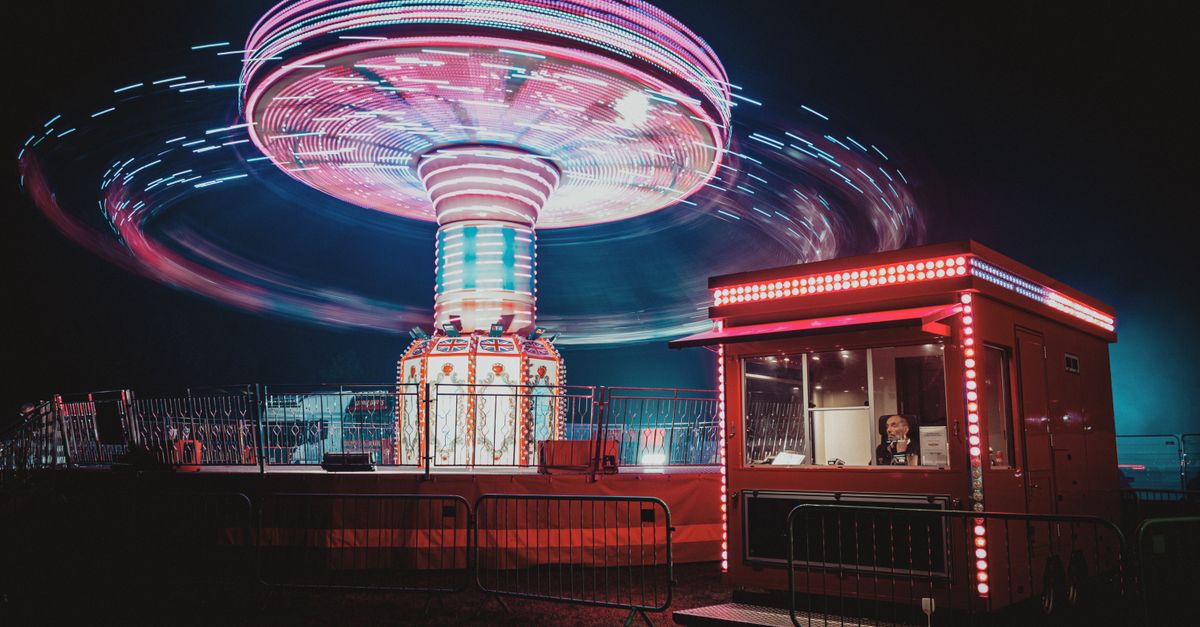 Vibrant image of a spinning fairground ride with neon lights at night.