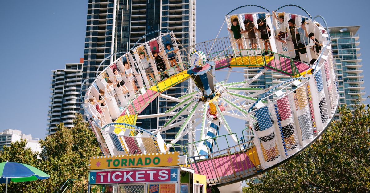 Exciting carnival ride set against city skyscrapers, capturing a lively urban atmosphere.