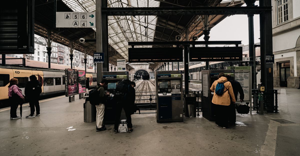 Travelers at ticket machines inside Sao Bento Railway Station, Porto.