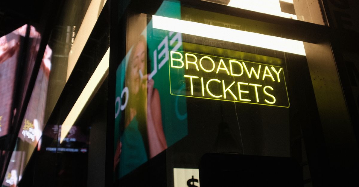 Vibrant neon Broadway tickets sign in New York City at night, capturing urban nightlife atmosphere.