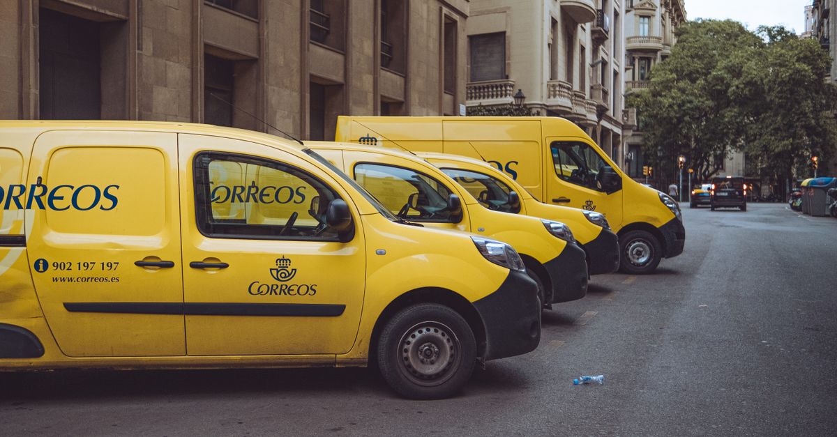 Three yellow delivery vans parked on a street in Barcelona, Spain, showcasing urban logistics.