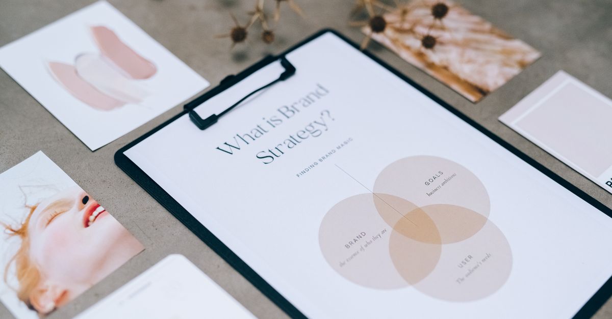 A close-up view of a brand strategy document on a desk surrounded by design artworks.