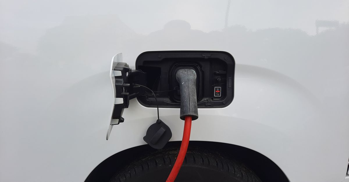 Close-up view of an electric vehicle charging port with a connected charging cable.