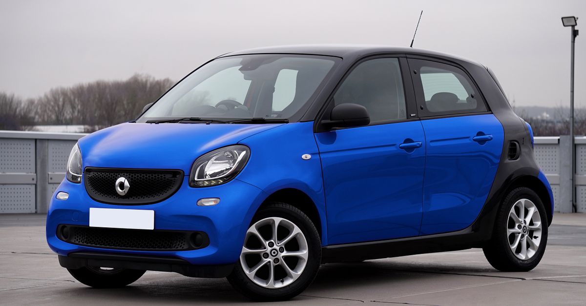 A sleek blue Smart Forfour car parked outdoors in an urban setting.