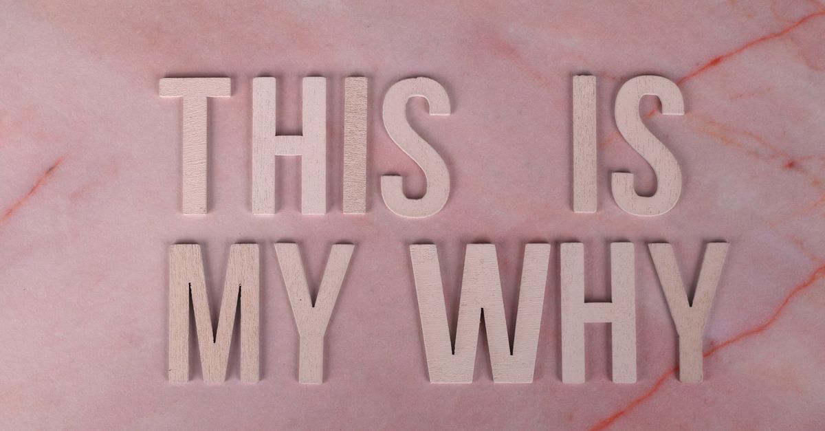 Wooden letters forming a motivational message on a pink marble backdrop, perfect for inspiration.