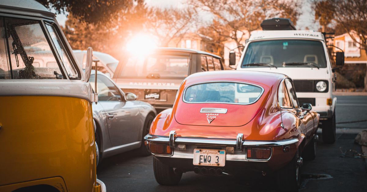 Classic red Jaguar E-Type Series 3 parked outdoors in San Diego at sunset, capturing a nostalgic vibe.