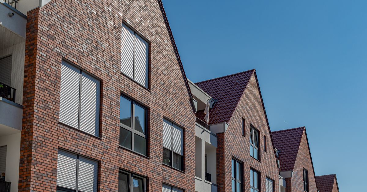 Contemporary brick apartment buildings under a clear blue sky in Coesfeld, Germany.