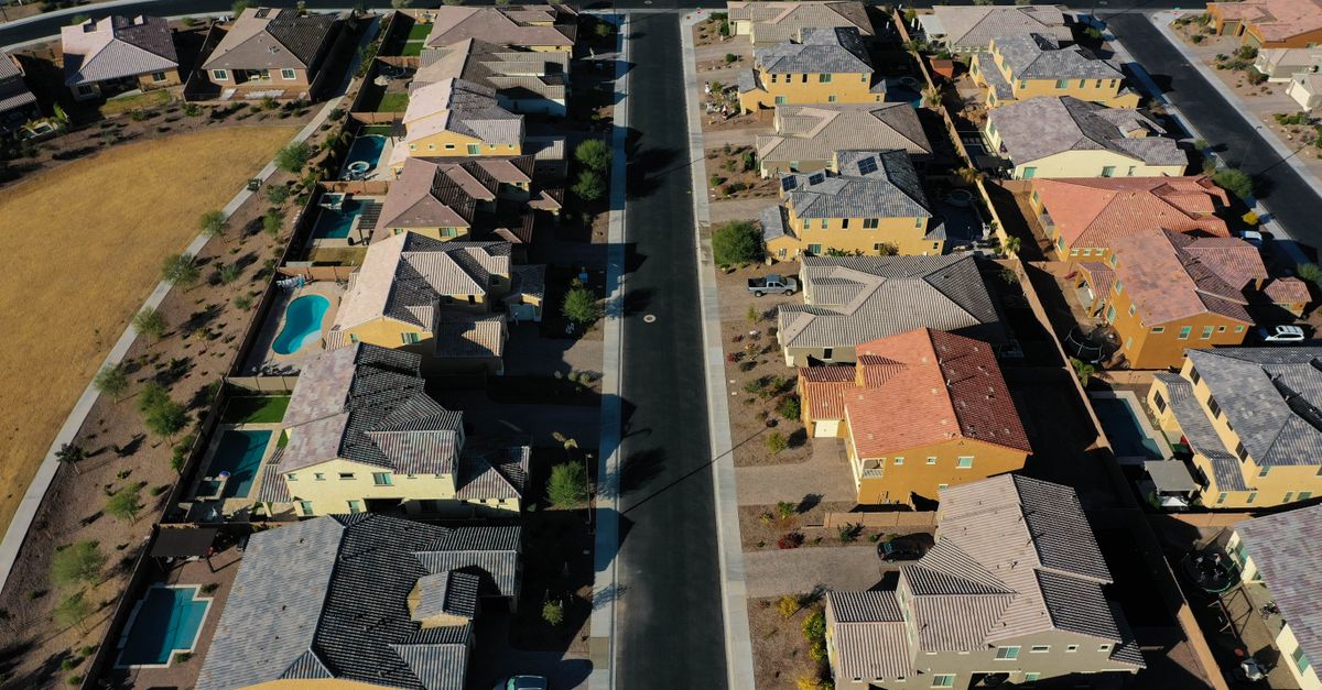 Aerial shot of a suburban residential area with neatly arranged houses and streets.