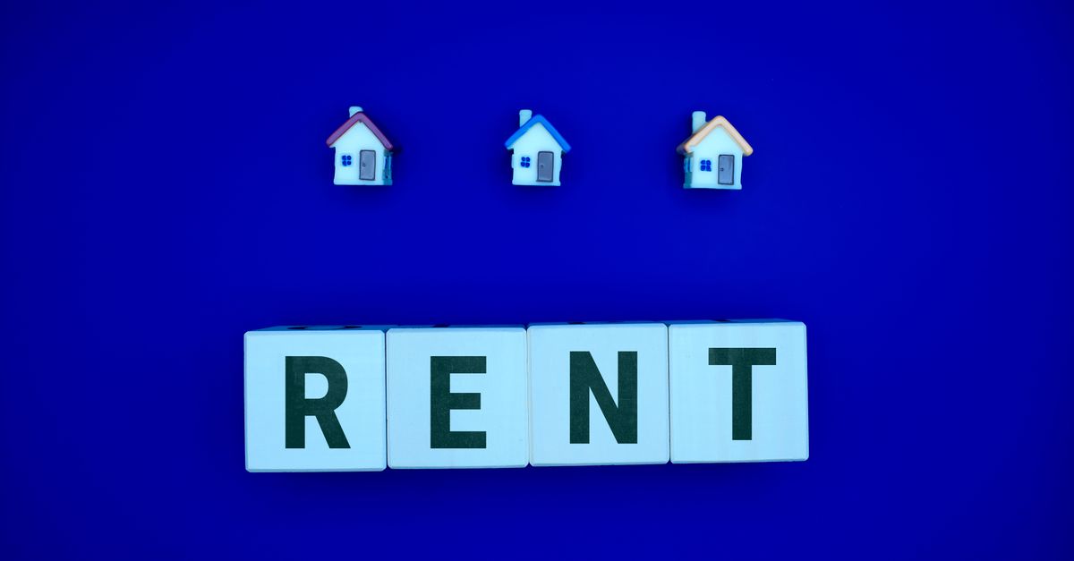 Miniature houses above letters spelling 'RENT' on a blue background, ideal for real estate themes.