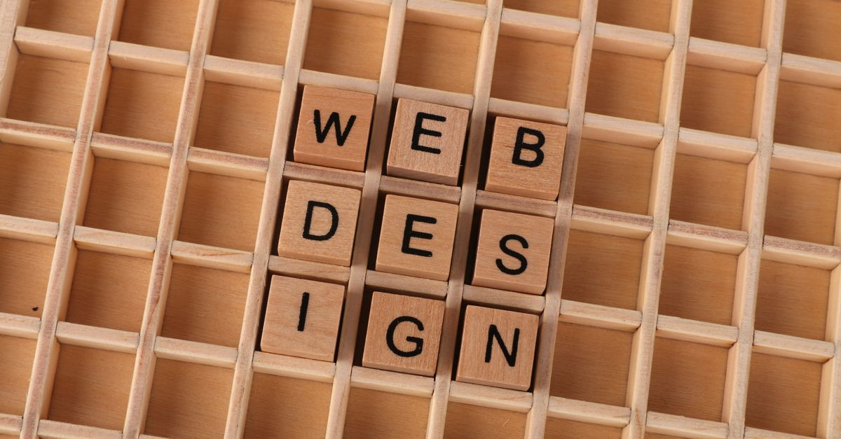 Wooden blocks spelling web design on a grid background symbolizing creative digital design concepts.