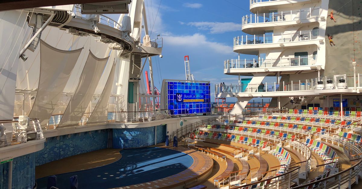 Vibrant cruise ship amphitheater with seating and stage in Barcelona, under a clear summer sky.