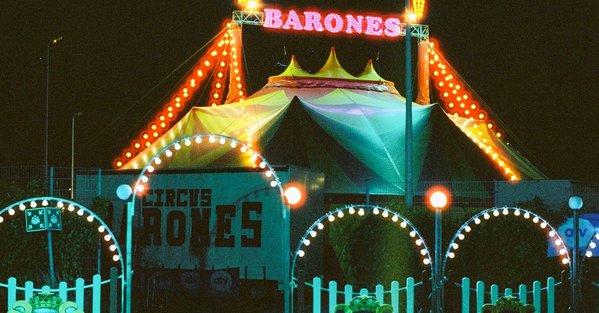 Vibrant neon circus tent with colorful lights during nighttime.