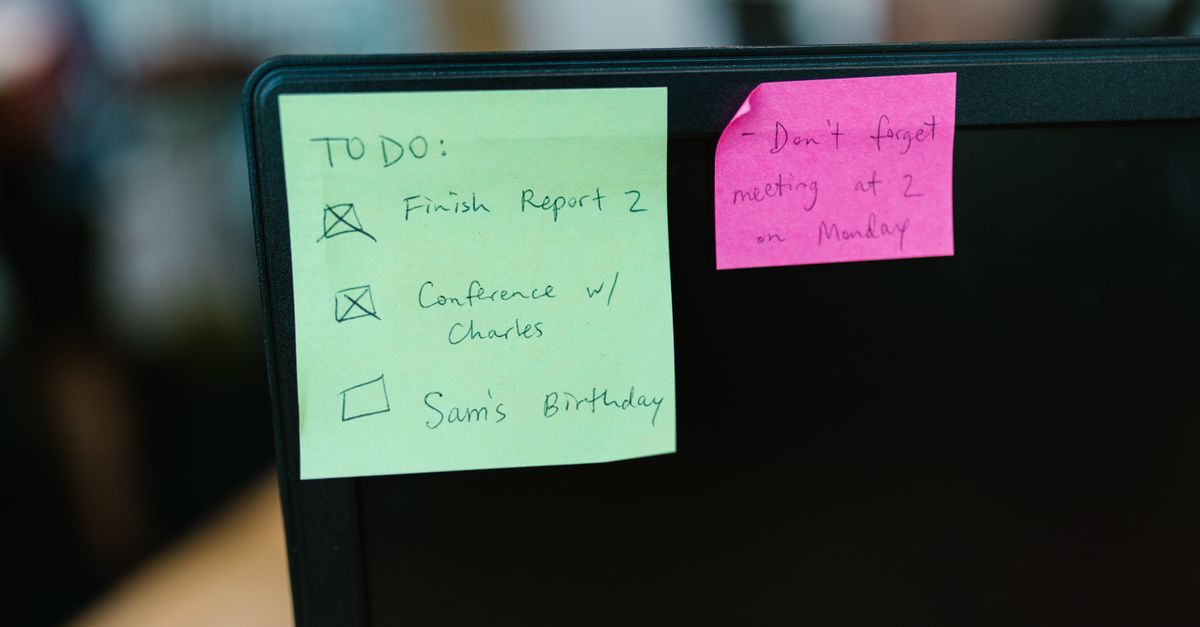 Colorful sticky notes with reminders and to-do list on an office monitor.
