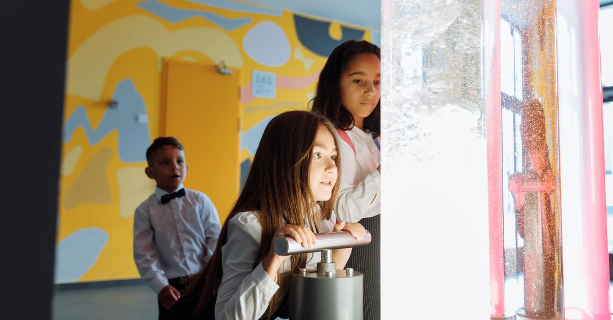 Children engage in a science experiment with colored liquids at school.