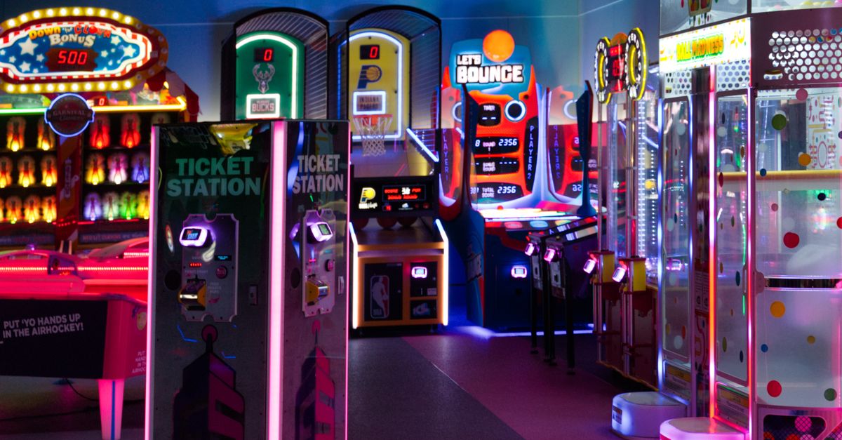 Brightly lit arcade games and ticket stations in a vibrant indoor entertainment center.