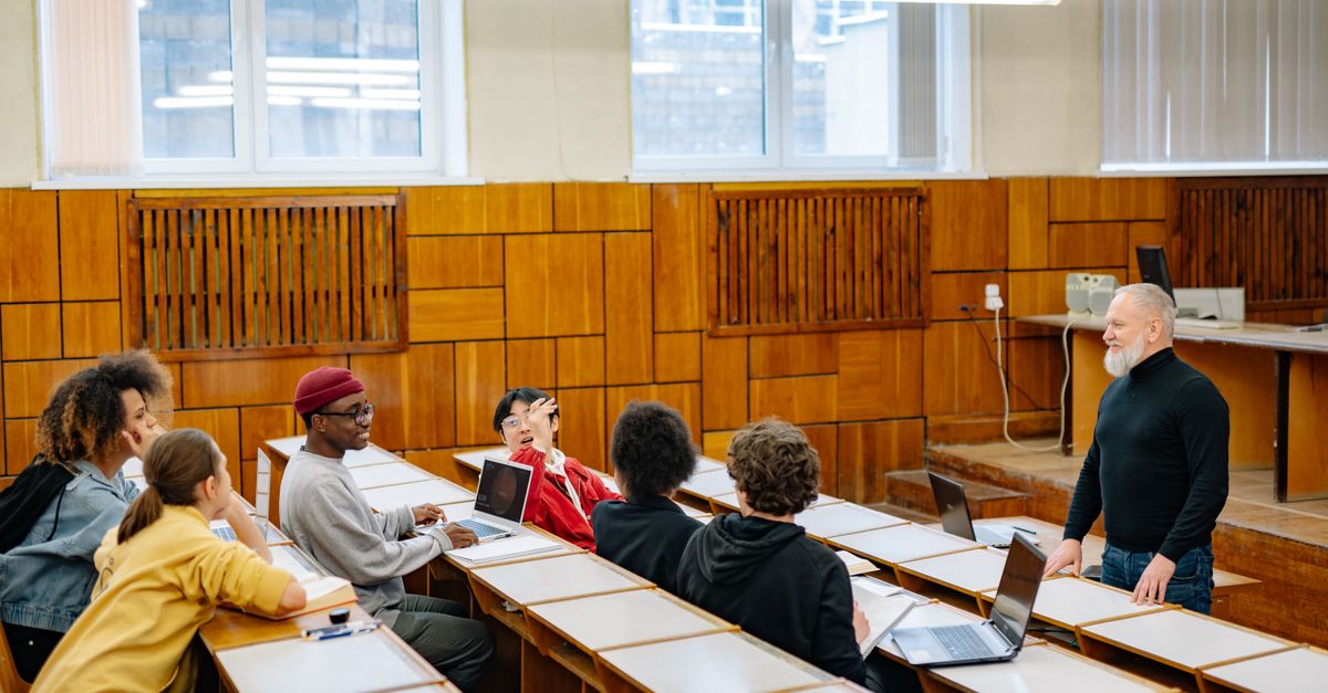 University students in a diverse classroom engaging in a discussion with their professor.