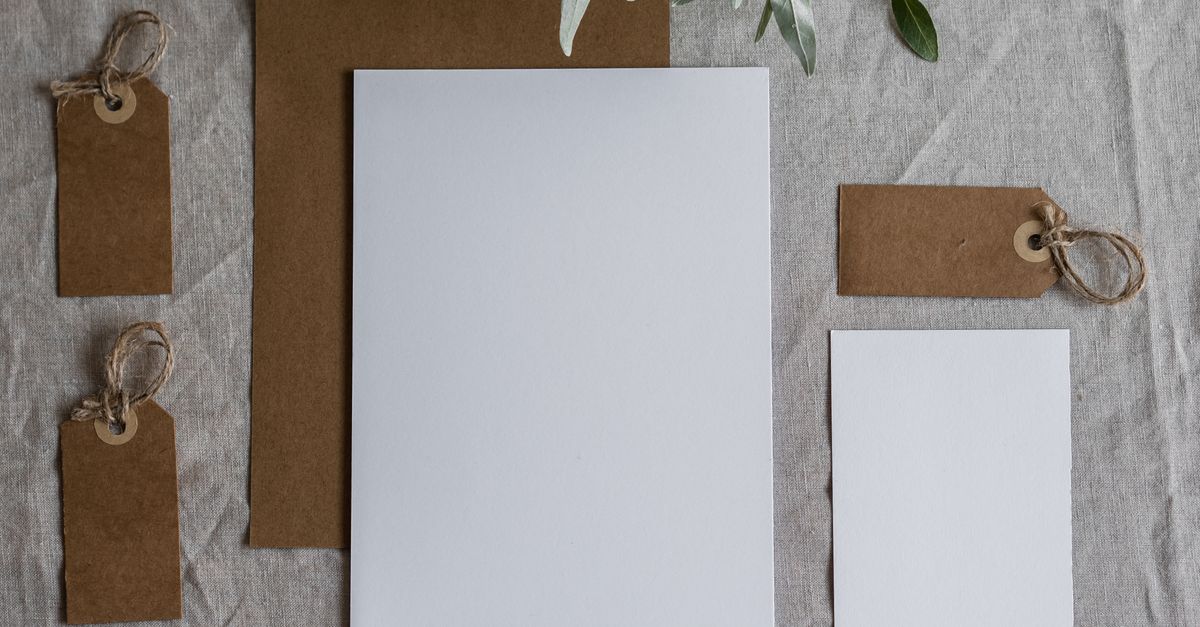 Flat lay of blank stationery with kraft tags on linen fabric, perfect for mockup.