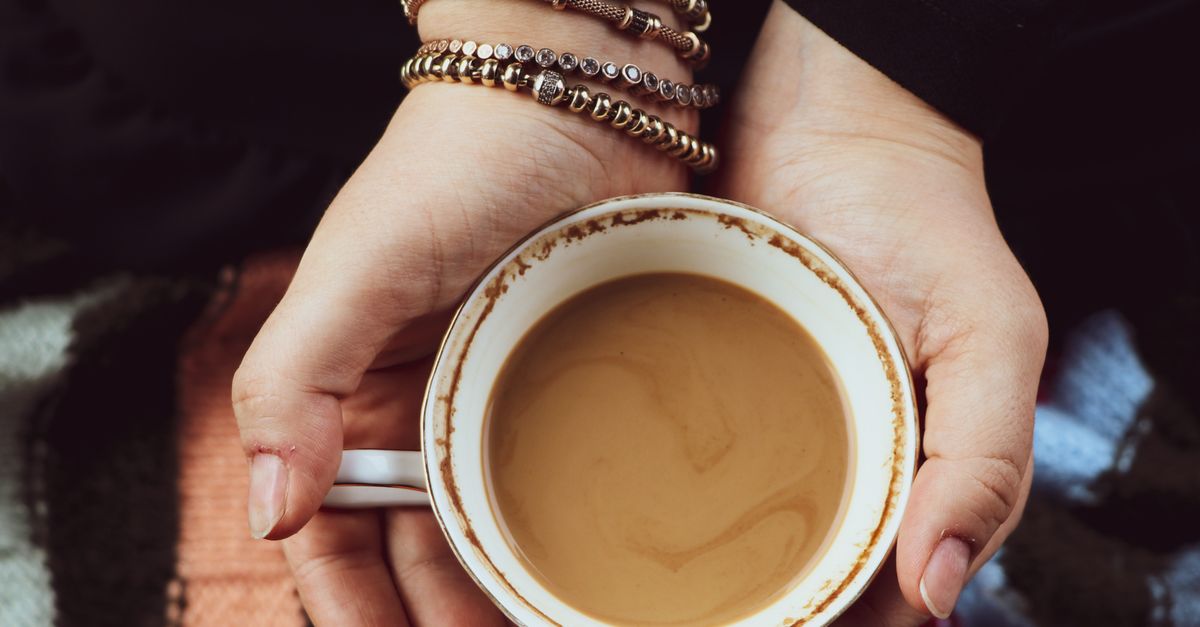 Close-up of hands holding a coffee cup, perfect for relaxing moments.