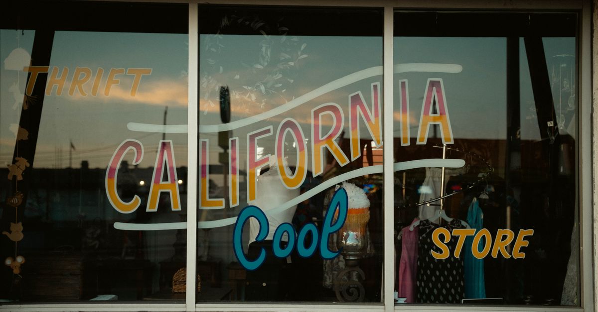 Vintage shop window with retro California thrift store signage and colorful display.