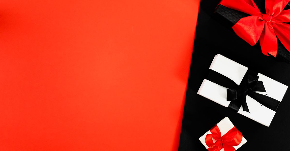 Stylish arrangement of presents with black and red ribbons over a vibrant background.