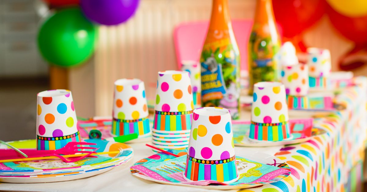 Colorful party table setup with polka dot cups and balloons, perfect for celebrations.