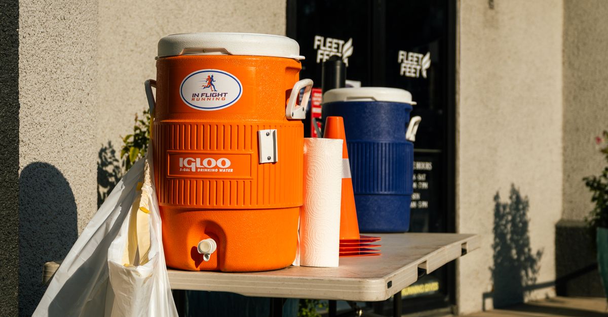 Bright outdoor scene with orange and blue water coolers at Fleet Feet store in Houston, TX.