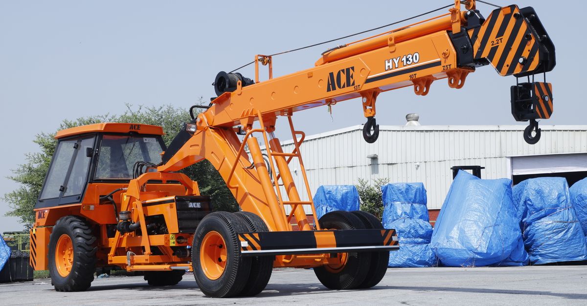 A bright orange ACE HY130 crane positioned outdoors in Faridabad, Haryana, India.