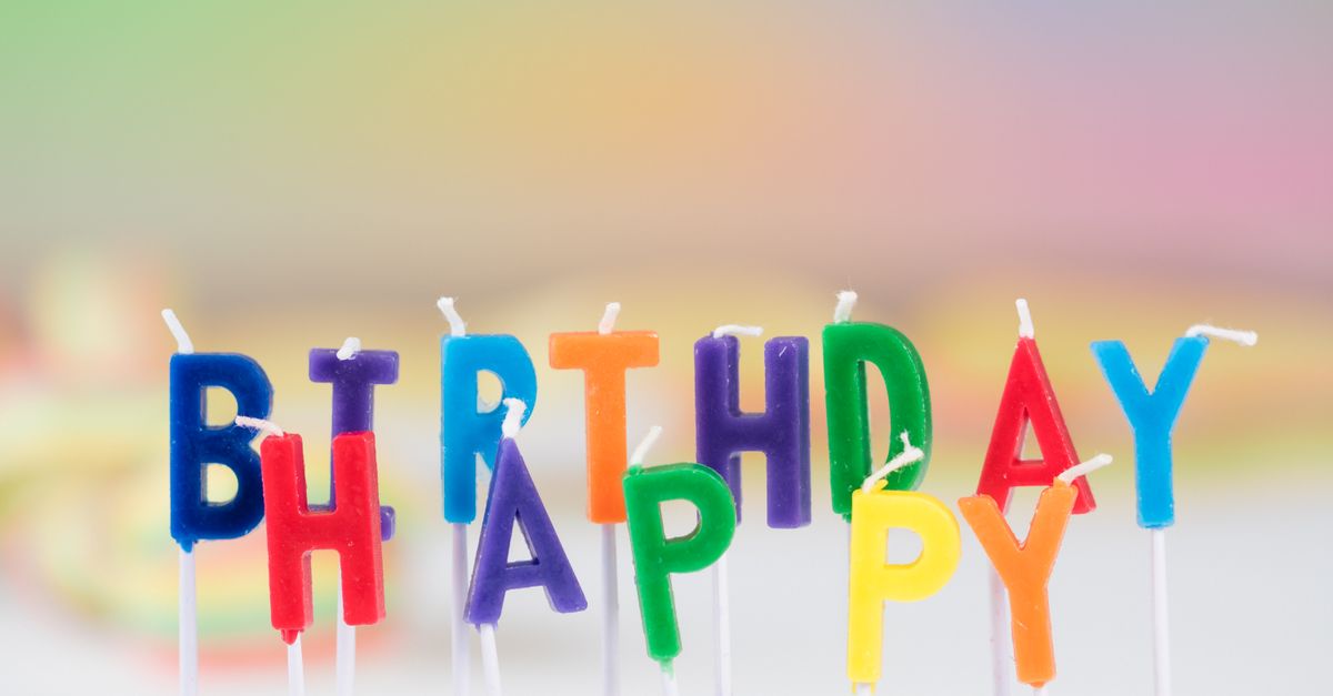 Vibrant birthday candle letters spelling 'Happy Birthday' with a colorful blurred background. Perfect for celebration visuals.