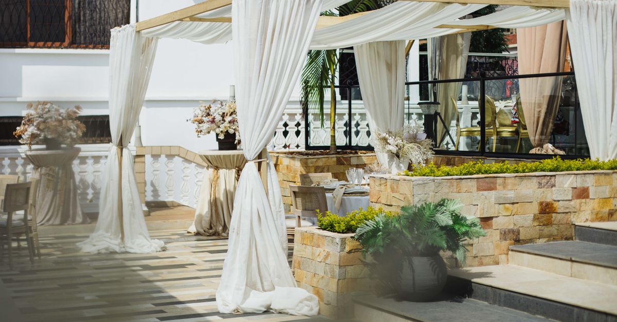 Elegant outdoor venue with draped canopies and decorative plants, ideal for events.