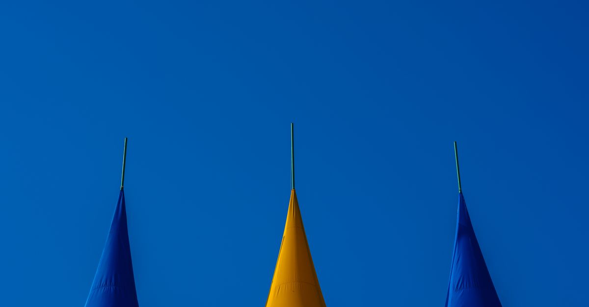Vibrant blue and yellow tents under a clear blue sky, perfect for backgrounds.
