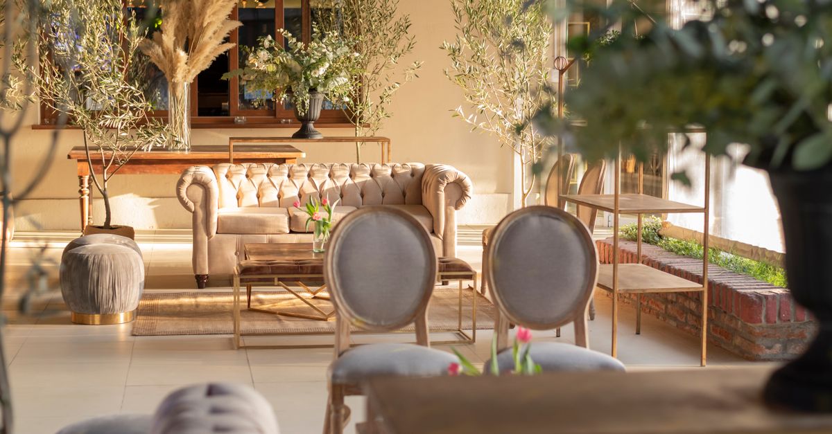 A sophisticated indoor lounge featuring classic furniture and greenery, perfect for events.