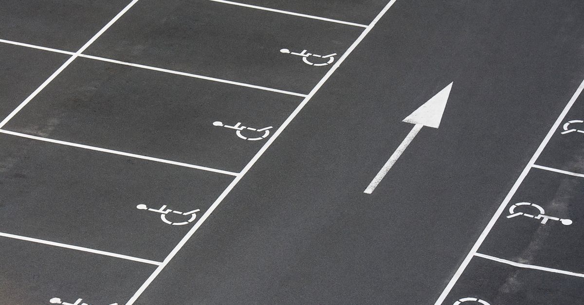 A clean parking lot featuring multiple handicapped spaces and a directional arrow marking.